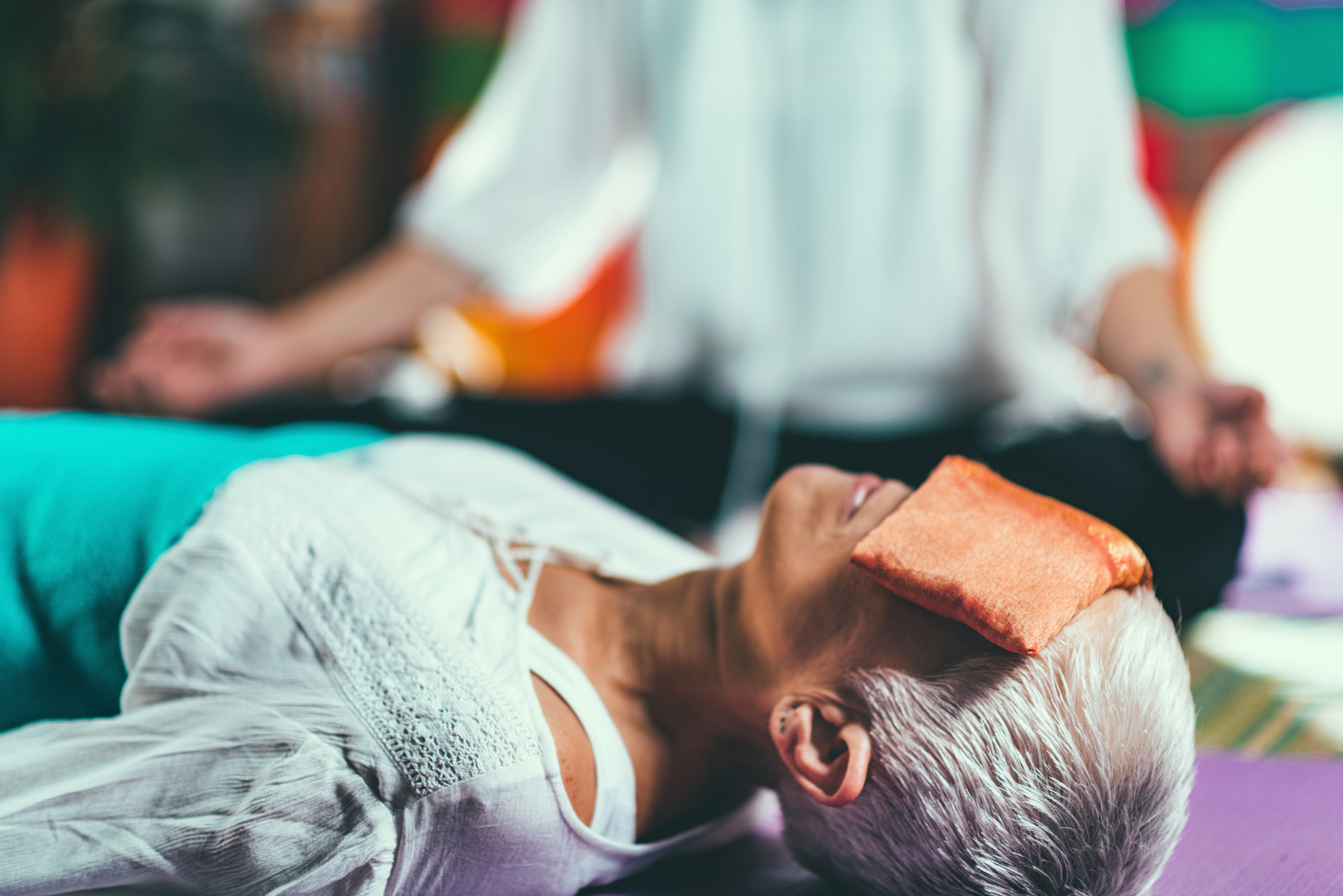 Senior woman lying on back on a guided meditation class